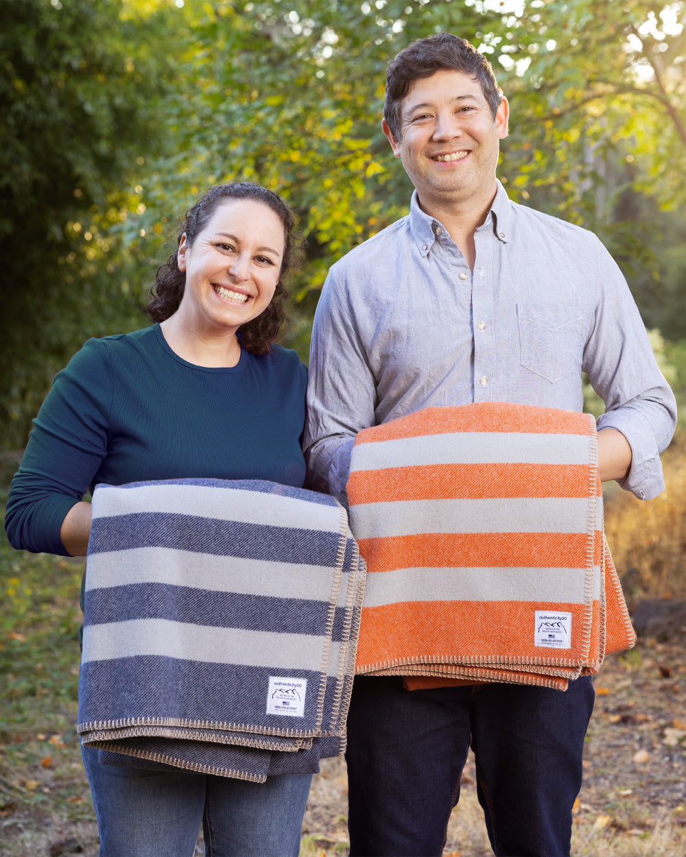 Authenticity50 co-founders Steph and Jimmy MacDonald holding folded Northwest Wool Throws (in Denim Blue and Mesa Sunset).