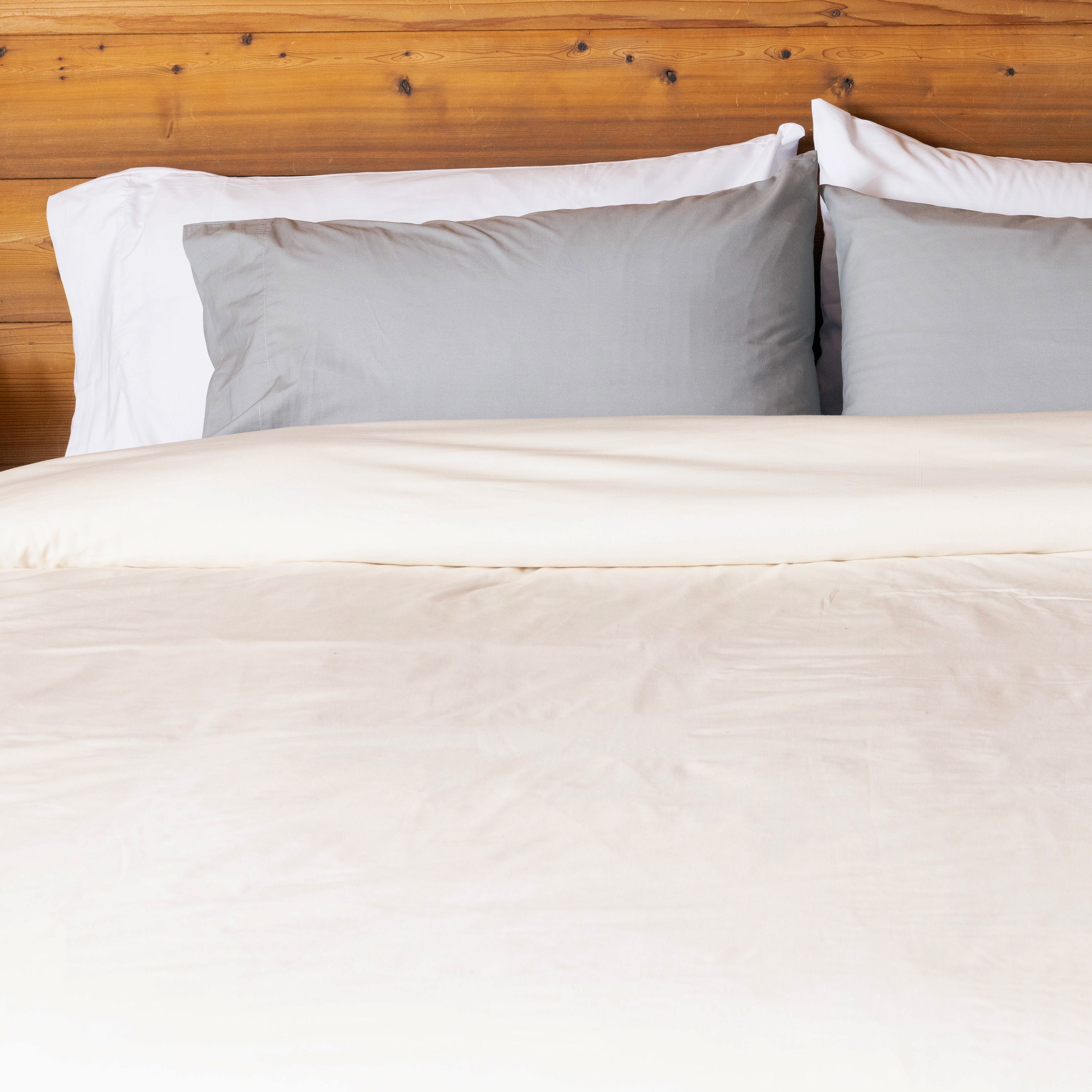 Bed made up with all three Heritage American Sheets colors (Rustic Cotton, Carolina Gray, and Cloud White).