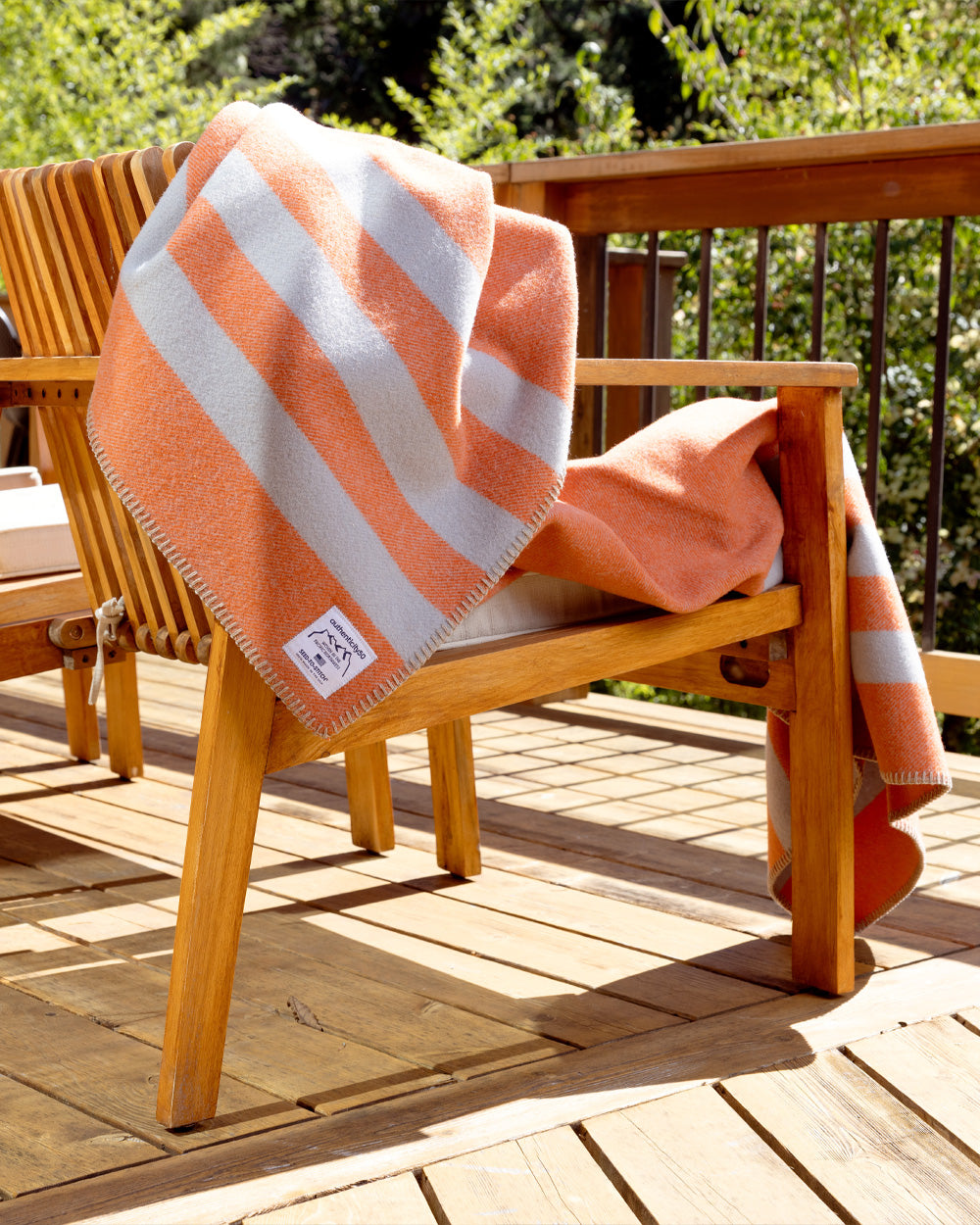Mesa Sunset Northwest Wool Throw draped over the back of a chair on a back deck.