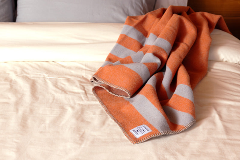 Mesa Sunset Northwest Wool Throw tossed casually at the head of a bed.
